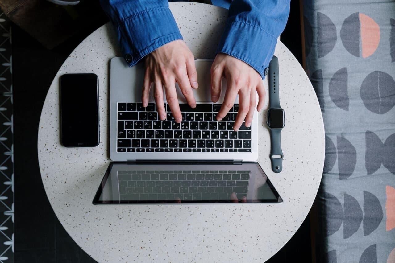 Person using a laptop and smartphone at a desk