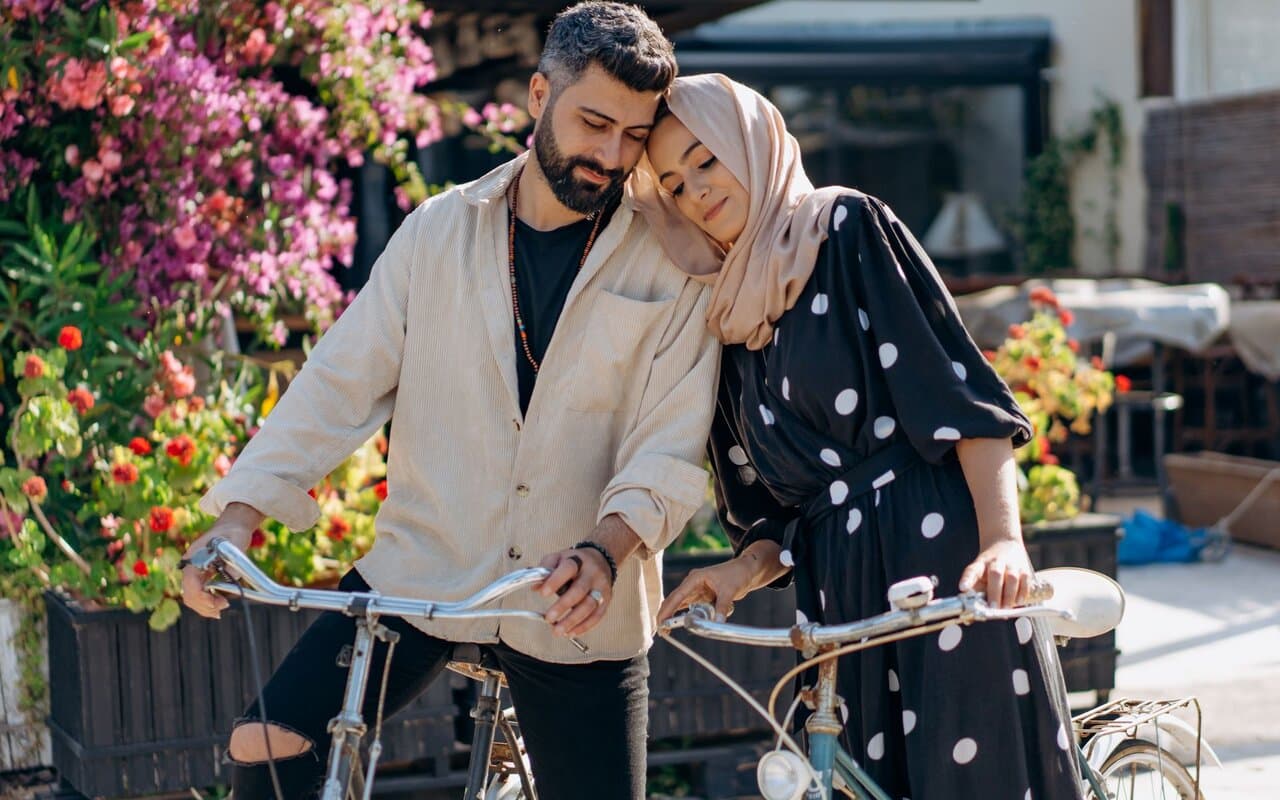Couple leaning on their bicycles together outdoors